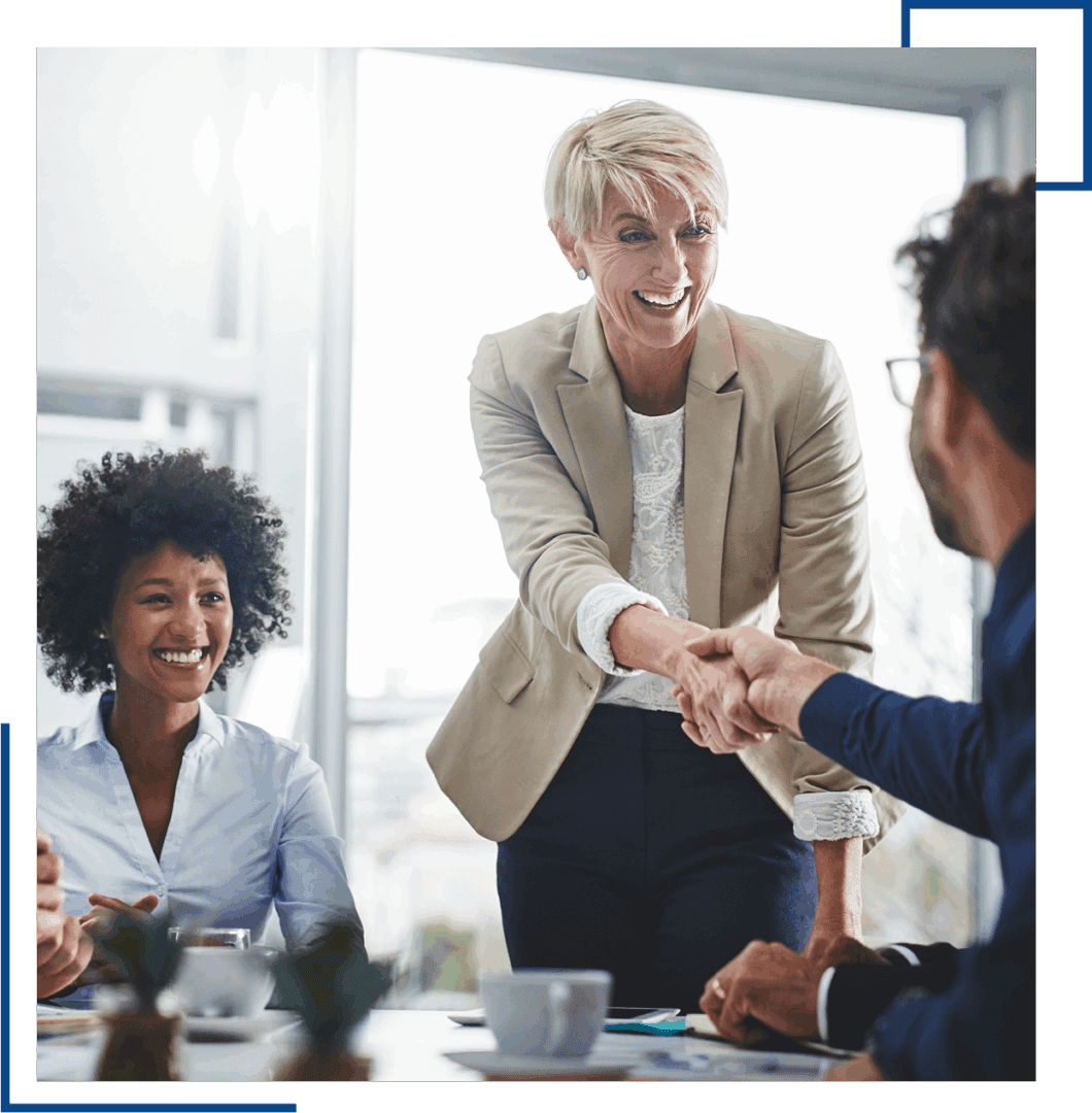 Business meeting handshake with smiling colleagues.