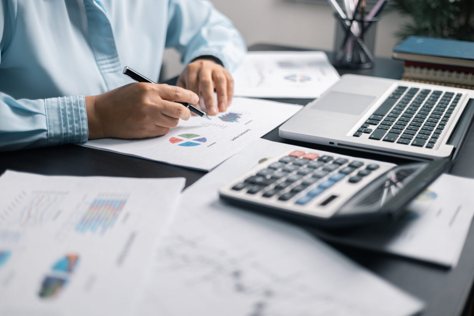 Person analyzing financial documents and charts.